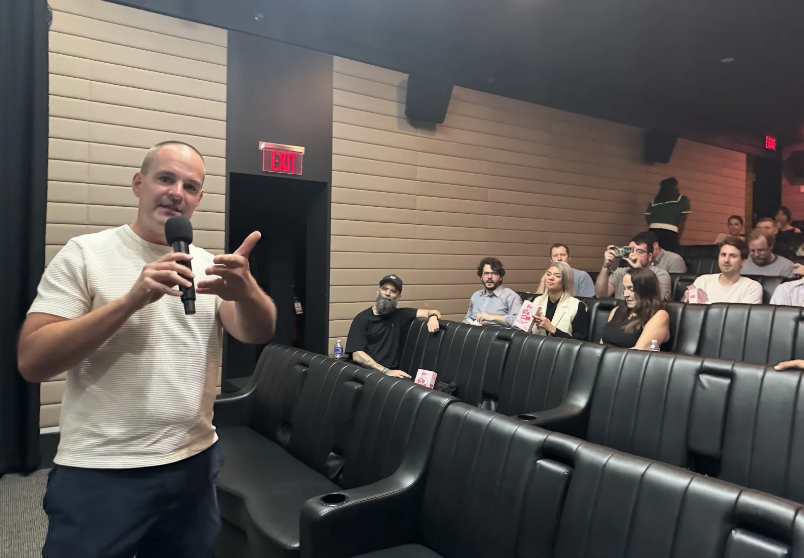 Roger Dickerman, the host, addressing the audience with a microphone.